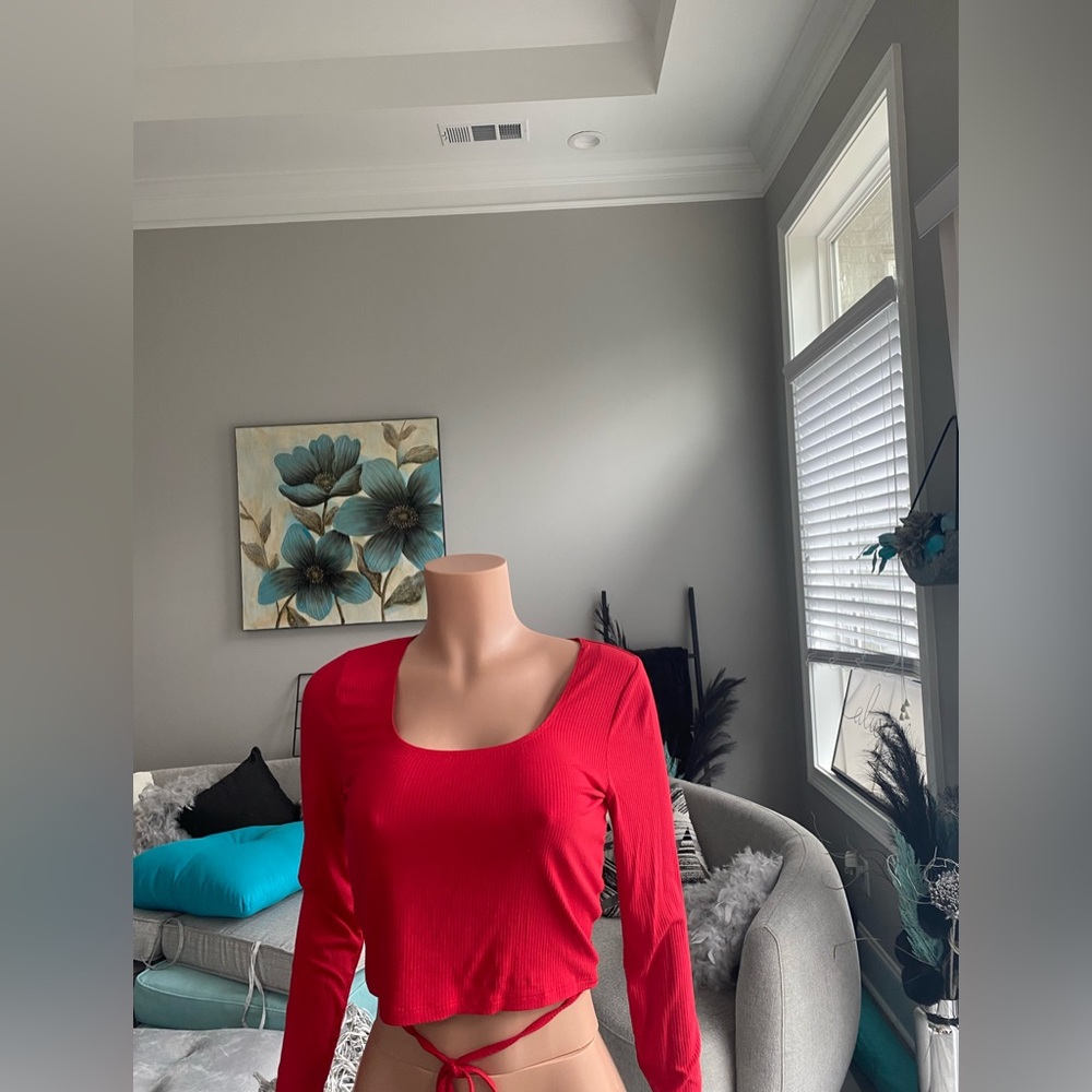 A long sleeve red shirt with strings to tie however you would like to